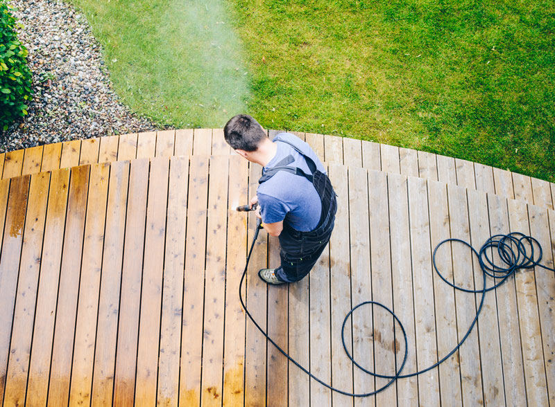 Pressure-washing-deck Man pressure washing a wood deck